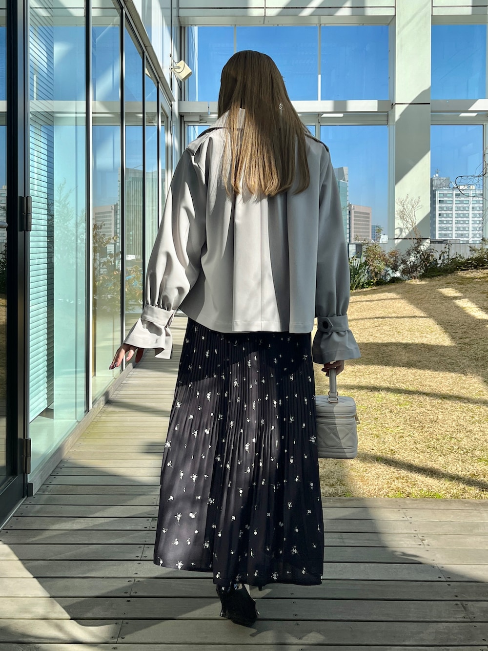 グレー系のトレンチコート、グリーン系のシャツ/ブラウス、ブラック系のスカートを着用したレディースの冬コーディネートの3枚目の写真