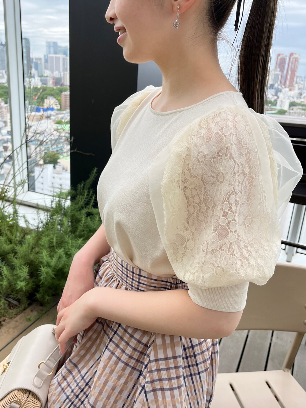 ホワイト系のニット/セーター、グレー系のショルダーバッグ、ホワイト系のサンダルを着用したレディースの夏コーディネートの4枚目の写真