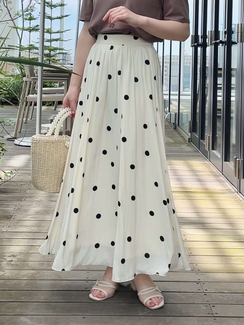 ホワイト系のスカート、ブラウン系のTシャツ/カットソーを着用したレディースの夏コーディネートの5枚目の写真