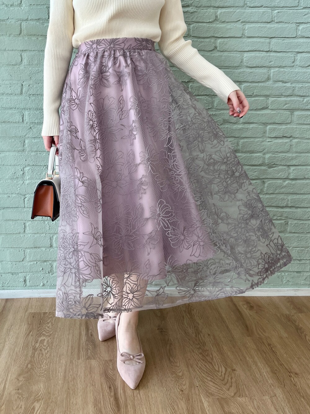 ホワイト系のニット/セーター、パープル系のスカートを着用したレディースの冬コーディネートの5枚目の写真