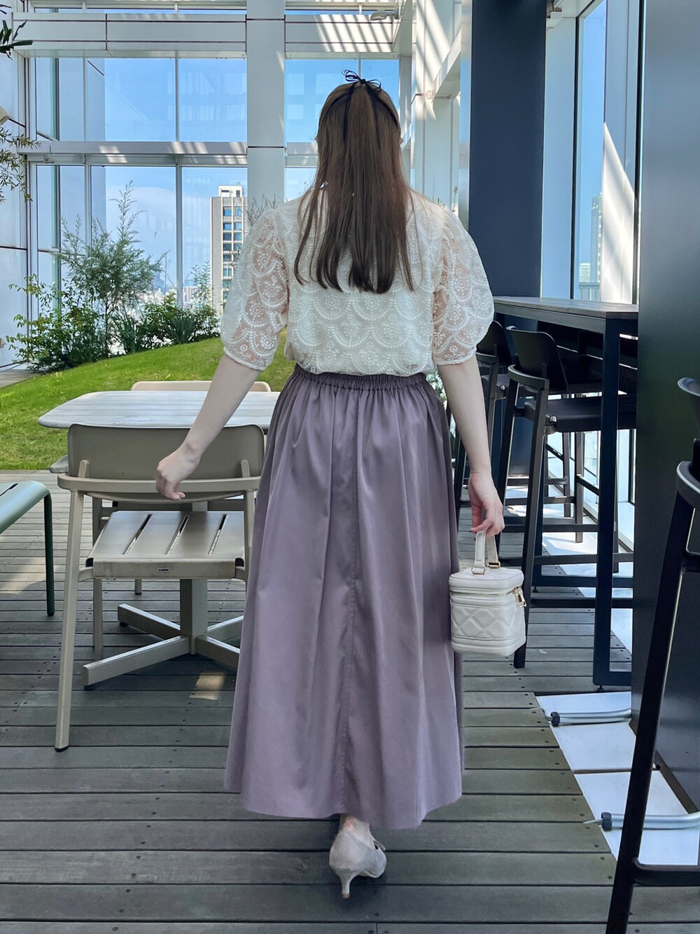 ホワイト系のTシャツ/カットソー、ホワイト系のショルダーバッグ、ブラウン系のスカートを着用したレディースの夏コーディネートの3枚目の写真