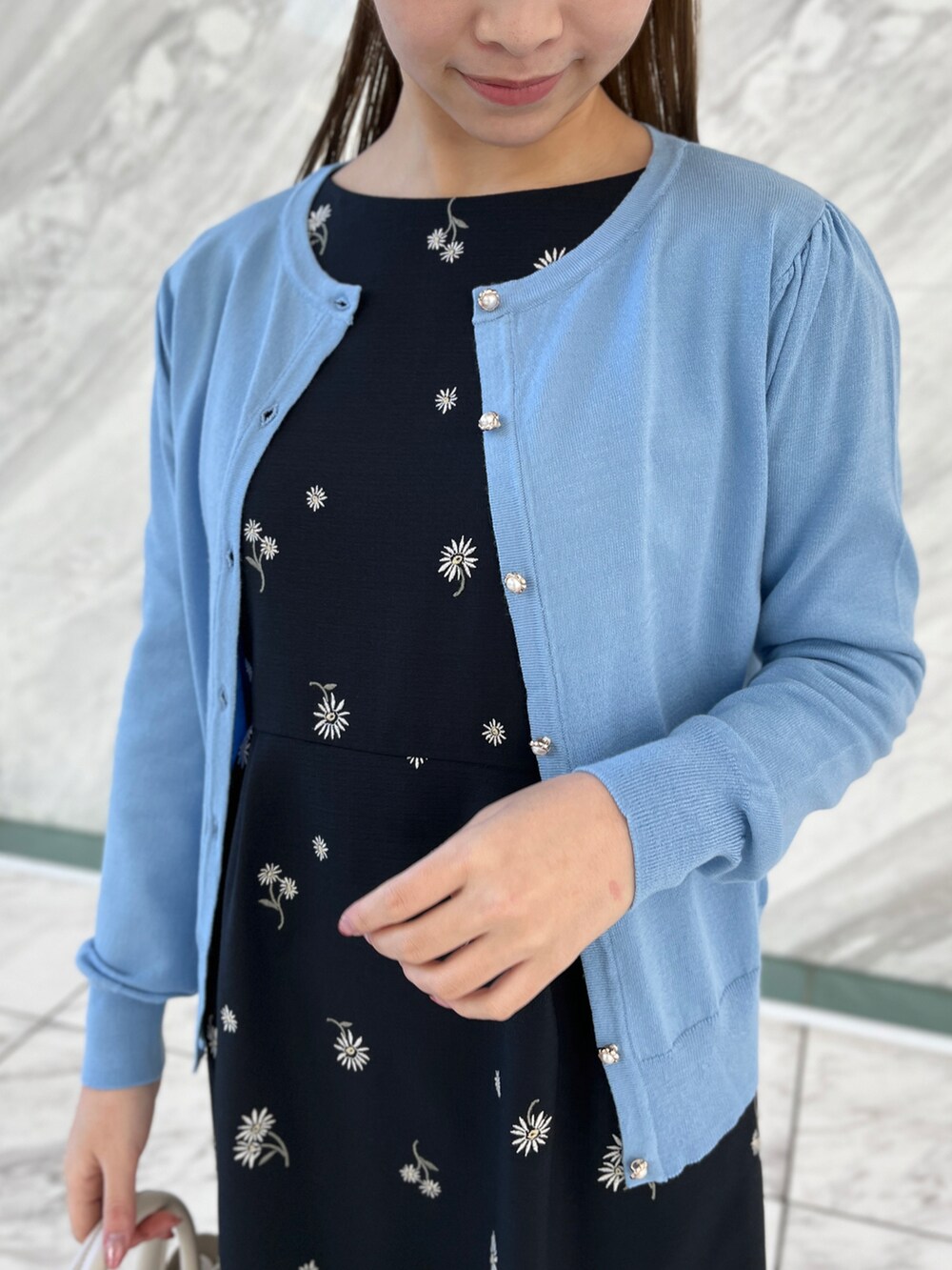 ブルー系のカーディガン/ボレロ、ブルー系のワンピース、ホワイト系のショルダーバッグを着用したレディースの冬コーディネートの4枚目の写真