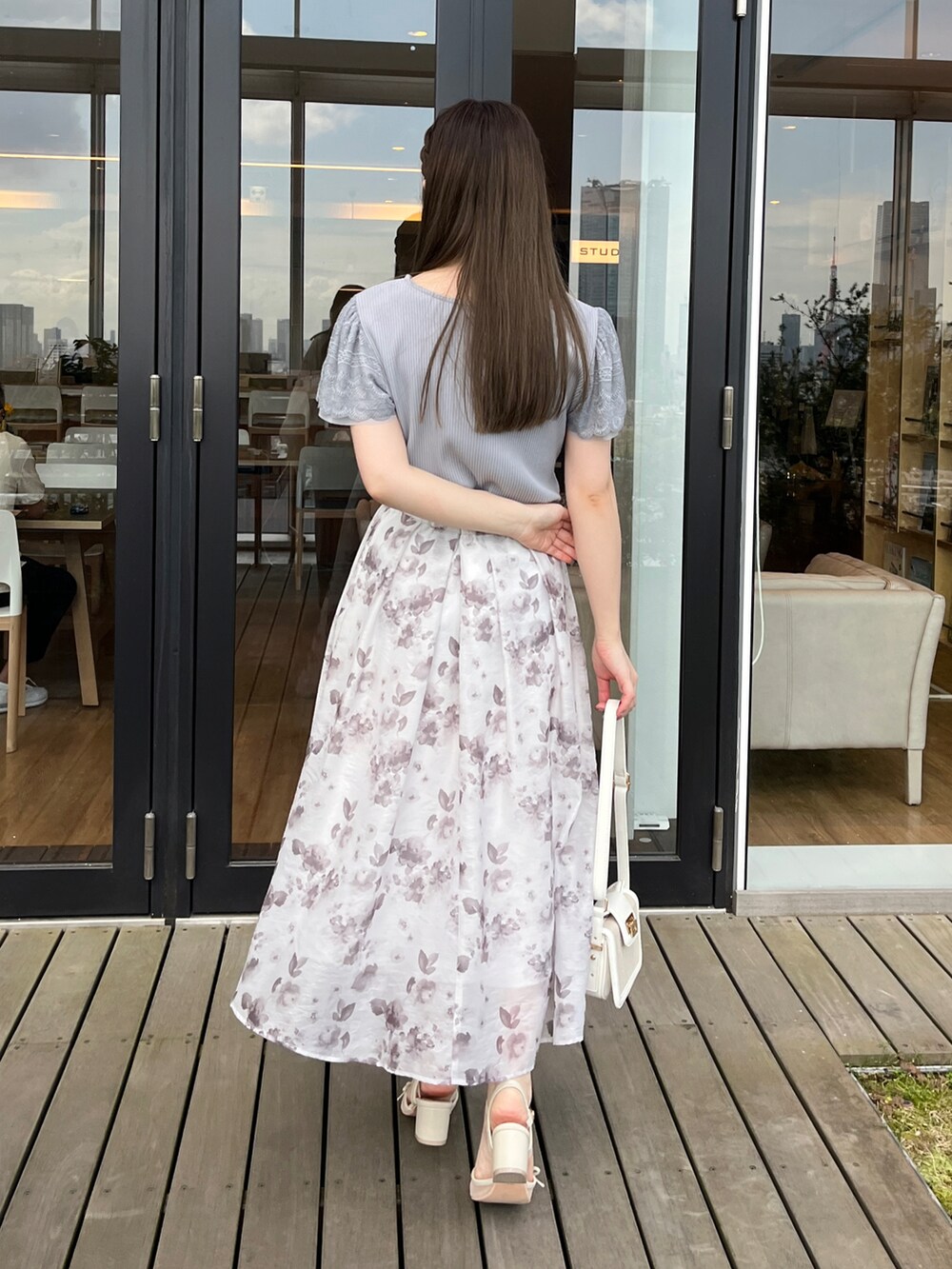 ブルー系のTシャツ/カットソー、ホワイト系のスカートを着用したレディースの春コーディネートの2枚目の写真