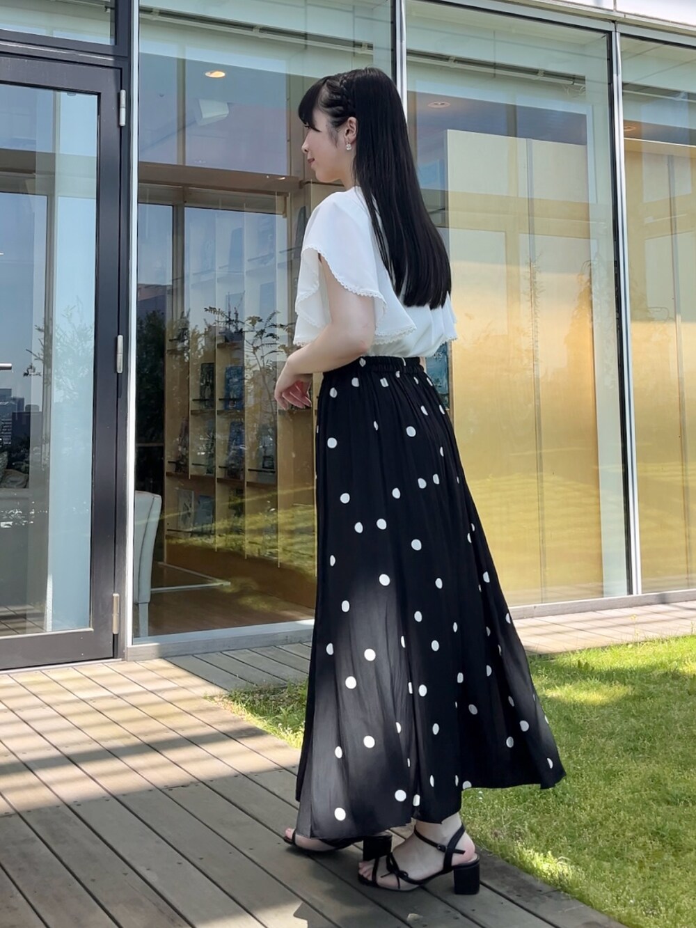 ホワイト系のTシャツ/カットソー、ブラック系のスカートを着用したレディースの夏コーディネートの2枚目の写真