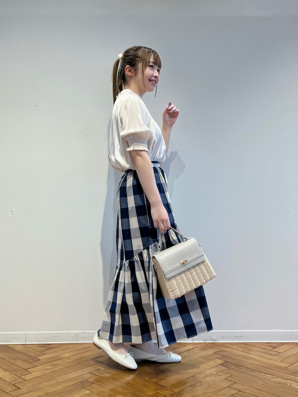 ホワイト系のシャツ/ブラウス、ブルー系のスカート、グレー系のショルダーバッグを着用したレディースの春コーディネートの2枚目の写真