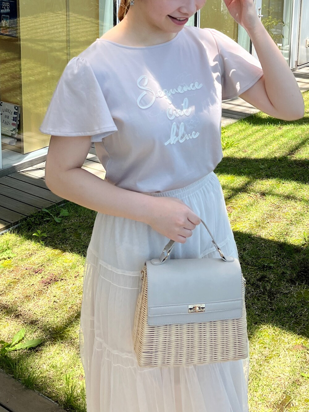 グレー系のTシャツ/カットソー、ホワイト系のスカート、グレー系のショルダーバッグを着用したレディースの夏コーディネートの4枚目の写真