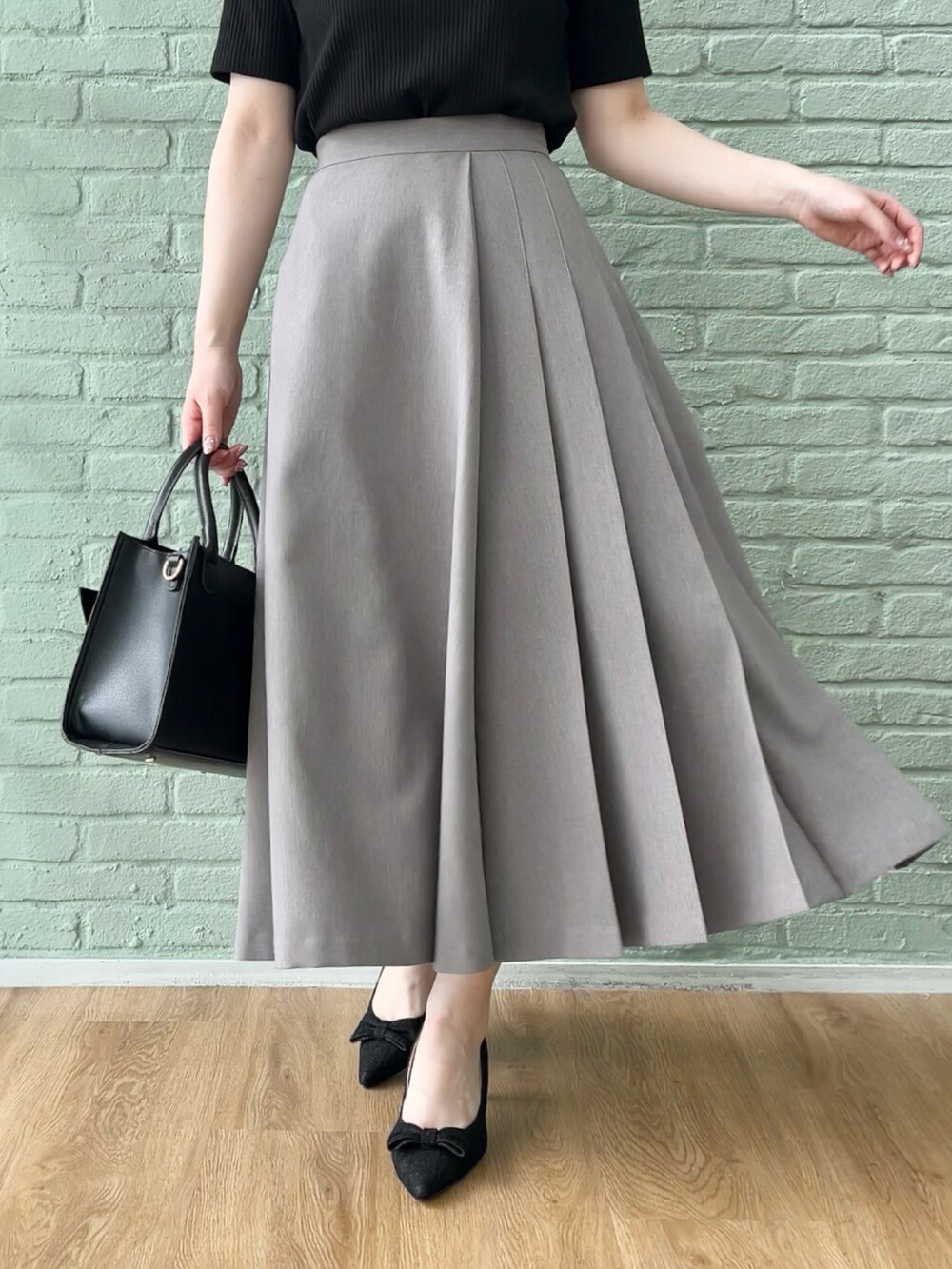 ブラック系のTシャツ/カットソー、ブラウン系のスカートを着用したレディースの秋コーディネートの5枚目の写真