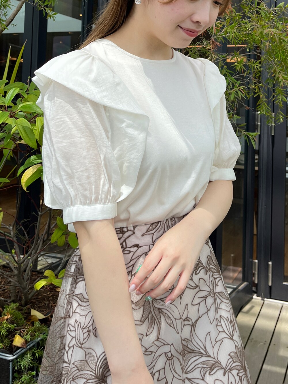 ホワイト系のTシャツ/カットソー、ブラウン系のスカート、ベージュ系のハンドバッグを着用したレディースの夏コーディネートの4枚目の写真