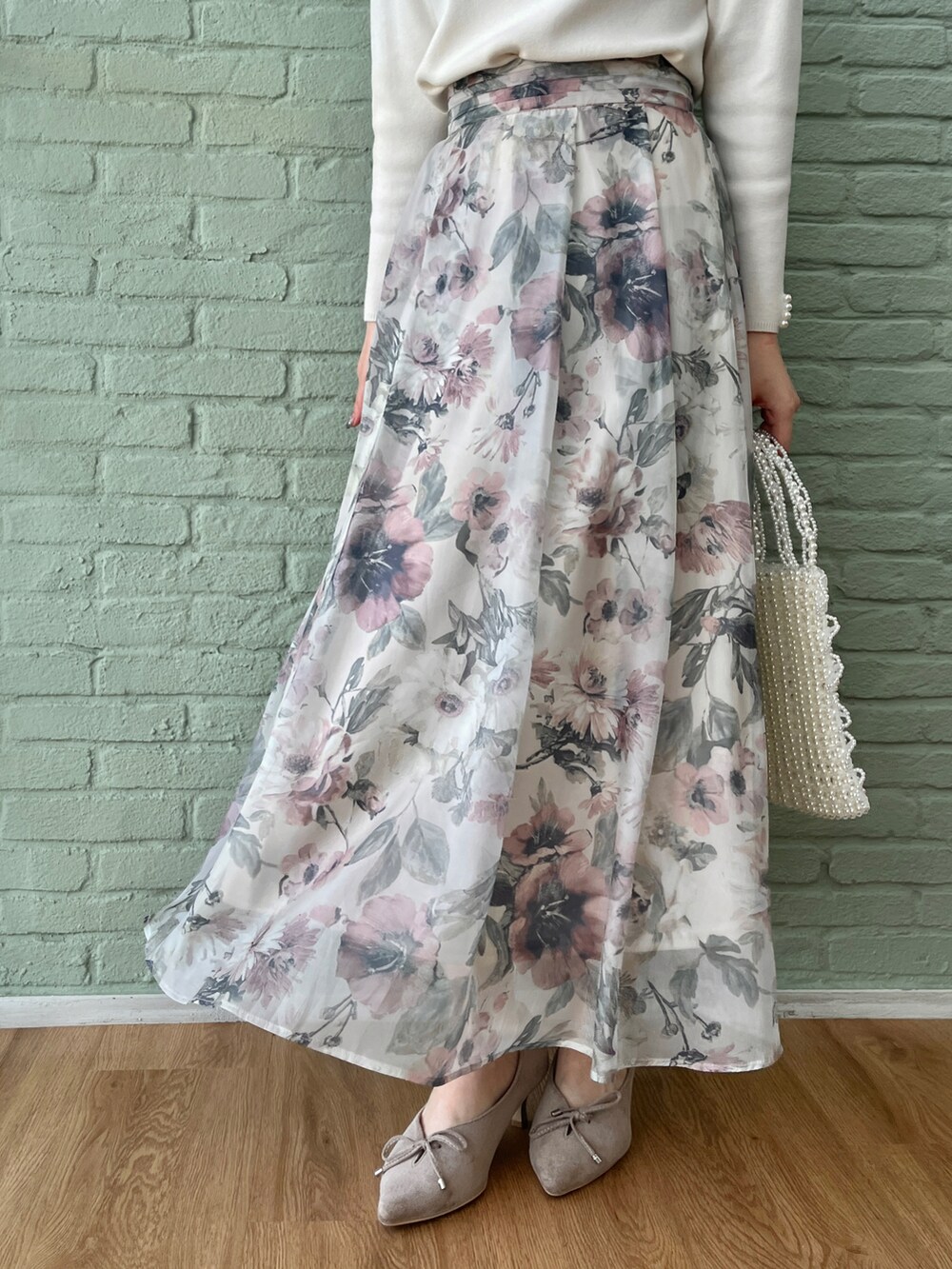 ホワイト系のニット/セーター、ベージュ系のスカートを着用したレディースの冬コーディネートの5枚目の写真