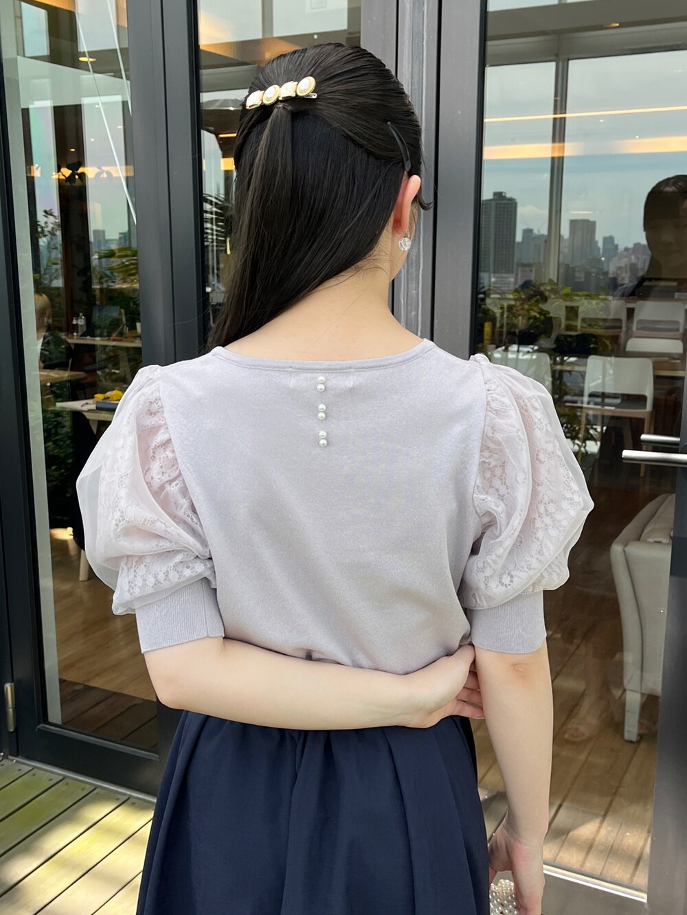 グレー系のニット/セーター、ブルー系のスカートを着用したレディースの春コーディネートの4枚目の写真