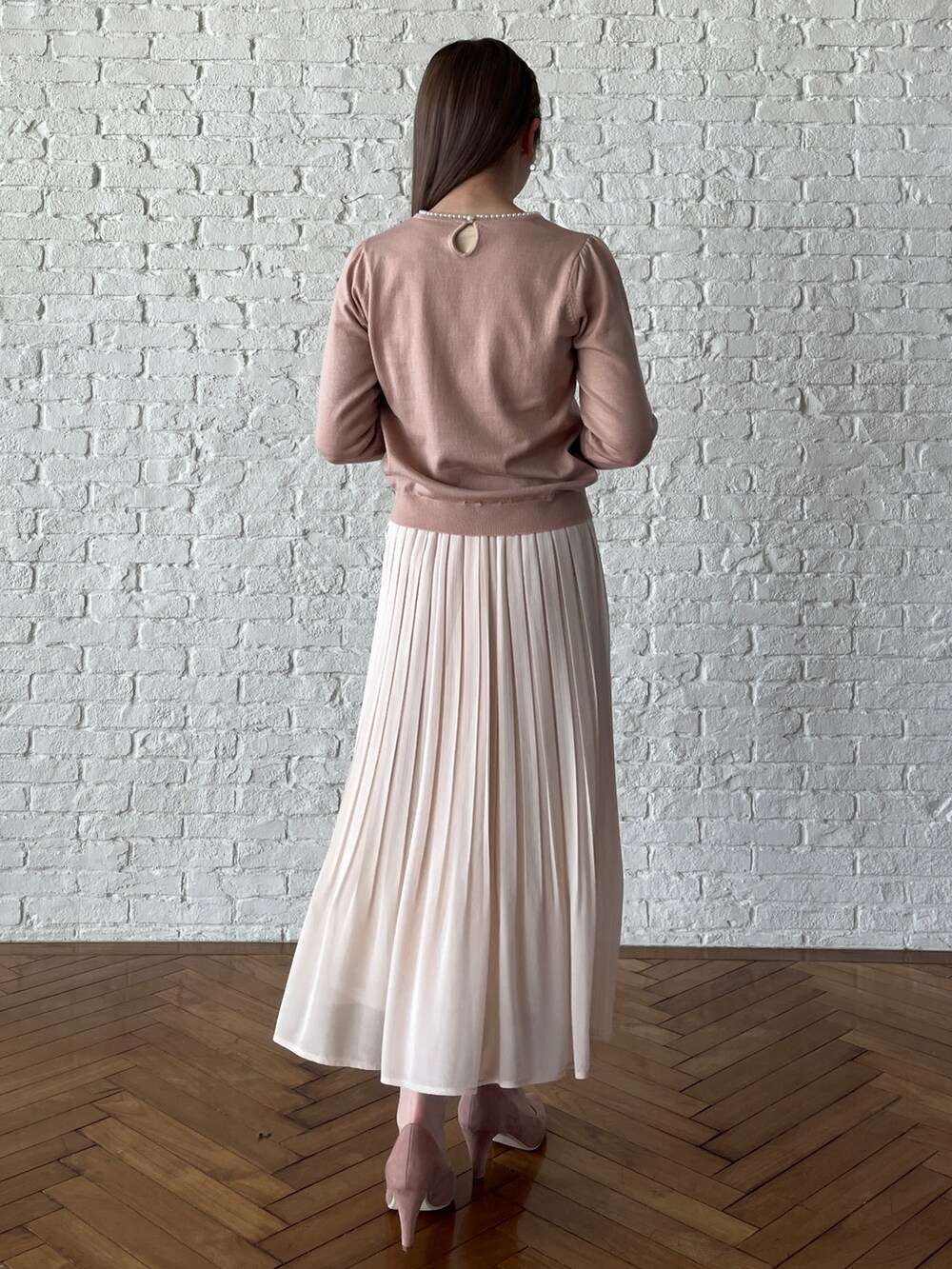 ピンク系のパンプス、ホワイト系のスカート、ピンク系のニット/セーターを着用したレディースの冬コーディネートの3枚目の写真