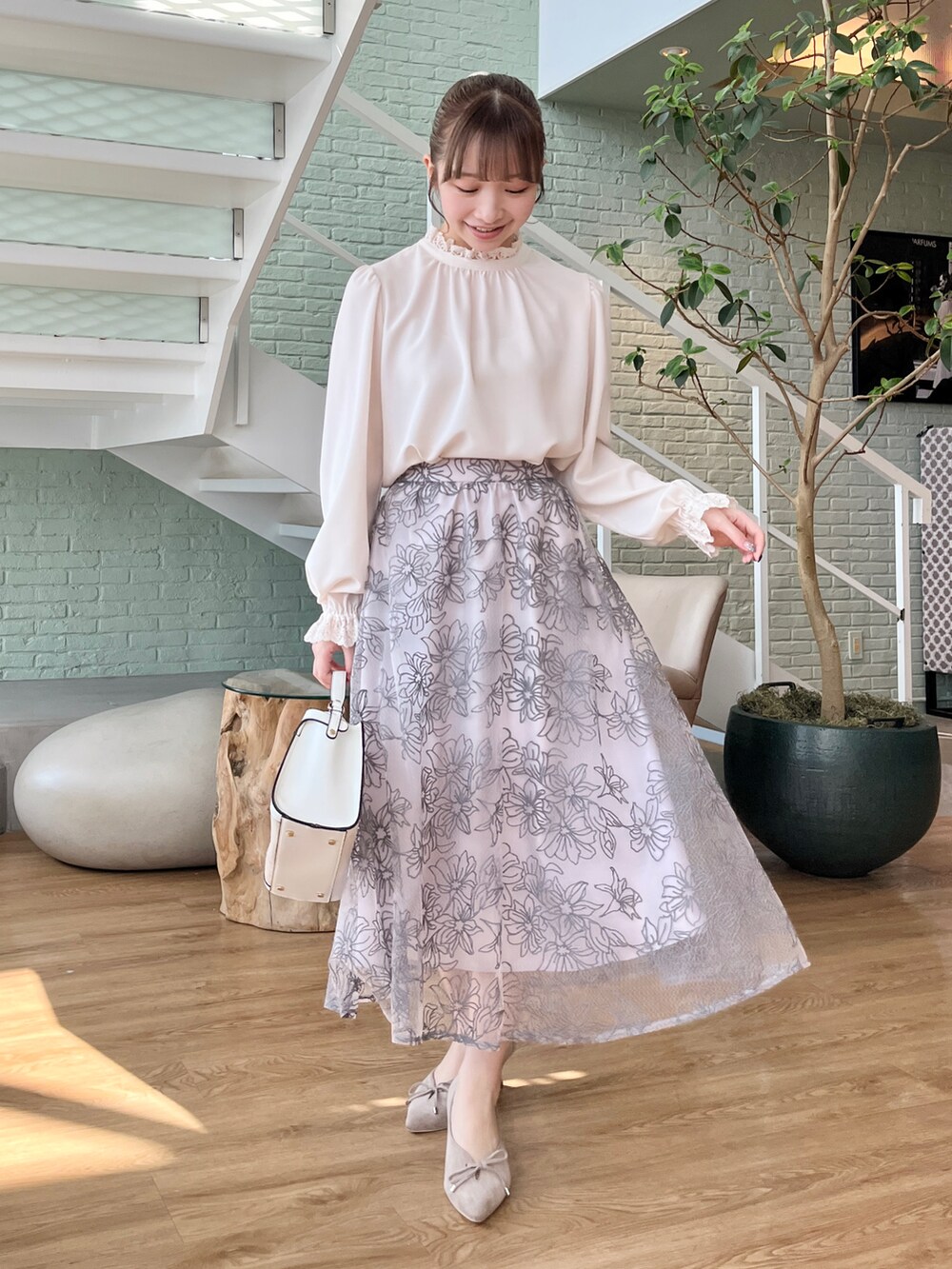 ホワイト系のカーディガン/ボレロ、ホワイト系のシャツ/ブラウス、グレー系のスカートを着用したレディースの冬コーディネートの5枚目の写真