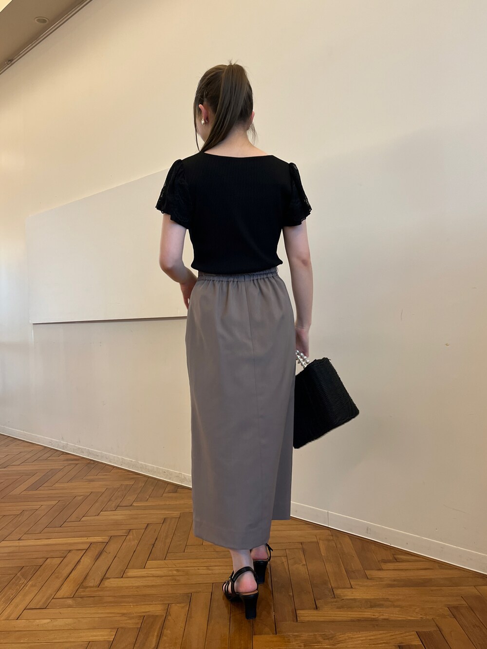 ブラック系のTシャツ/カットソー、ブラウン系のスカート、ブラック系のハンドバッグを着用したレディースの春コーディネートの3枚目の写真