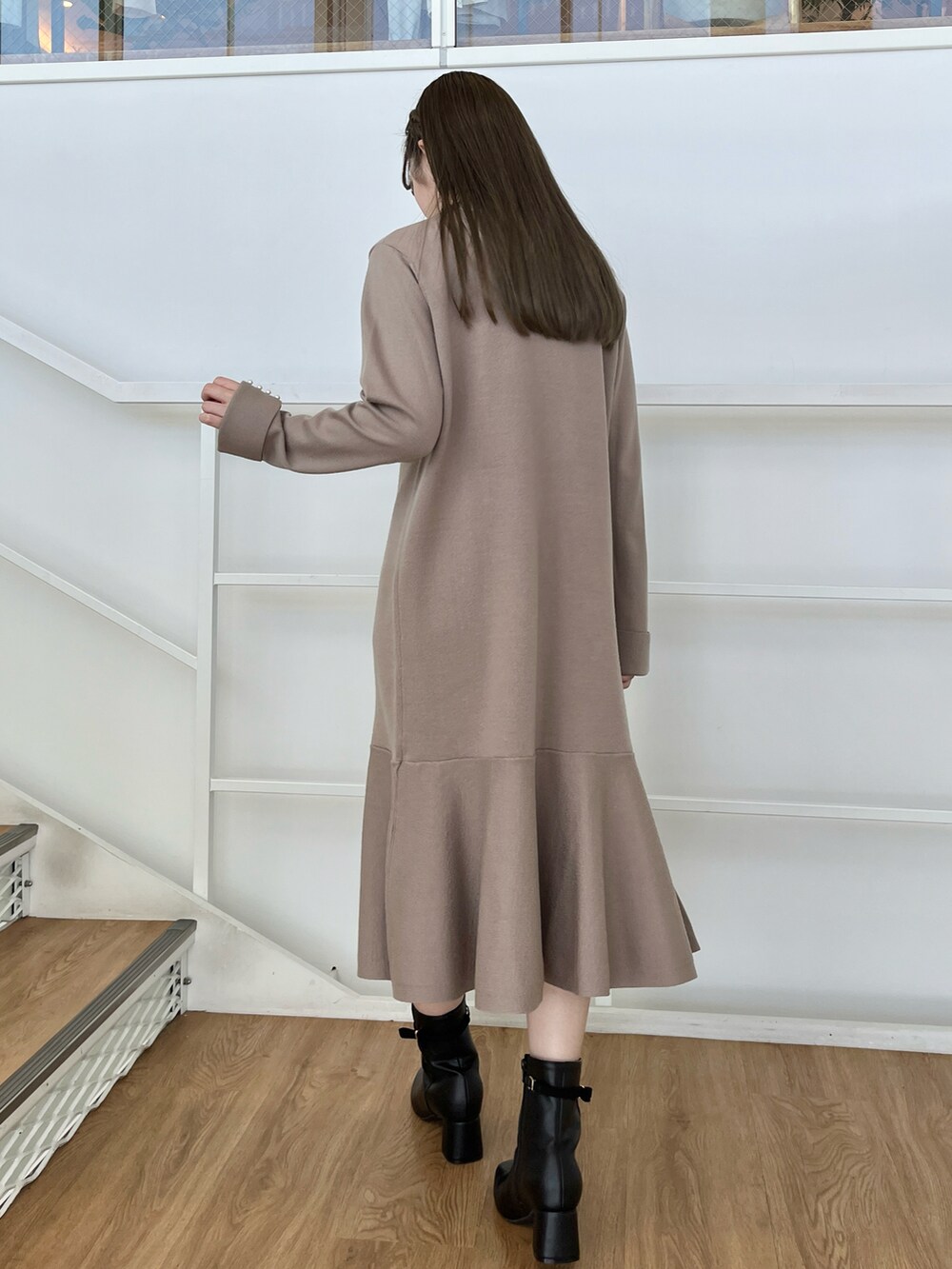 ブラック系のダウンジャケット/コート、ブラウン系のワンピースを着用したレディースの冬コーディネートの4枚目の写真