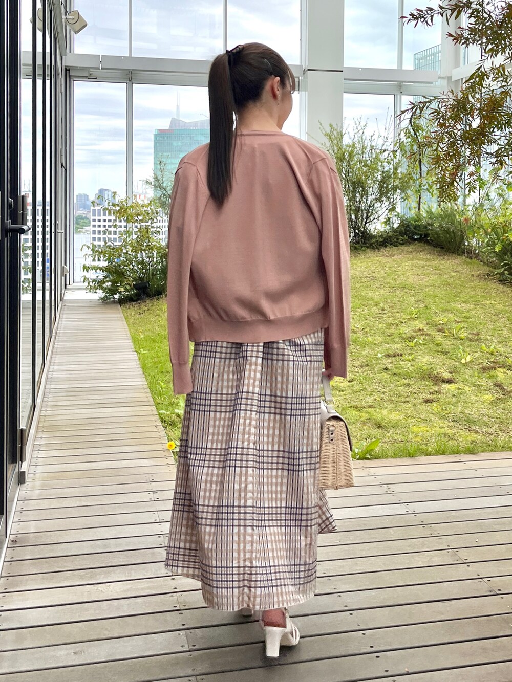 ホワイト系のニット/セーター、グレー系のショルダーバッグ、ホワイト系のサンダルを着用したレディースの夏コーディネートの3枚目の写真