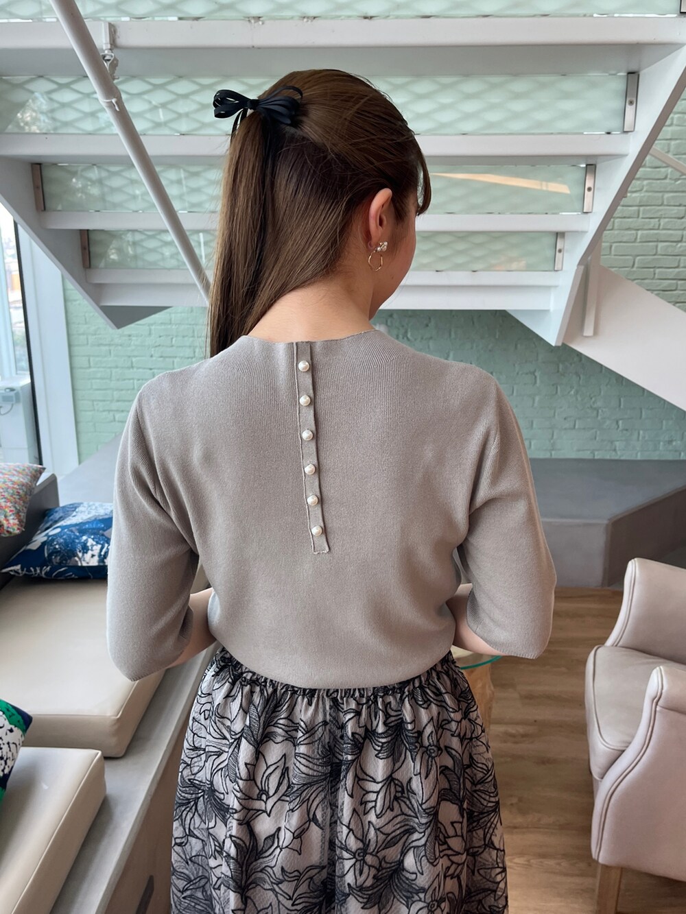 グリーン系のニット/セーター、ブラック系のショルダーバッグ、ブラック系のスカートを着用したレディースの夏コーディネートの4枚目の写真