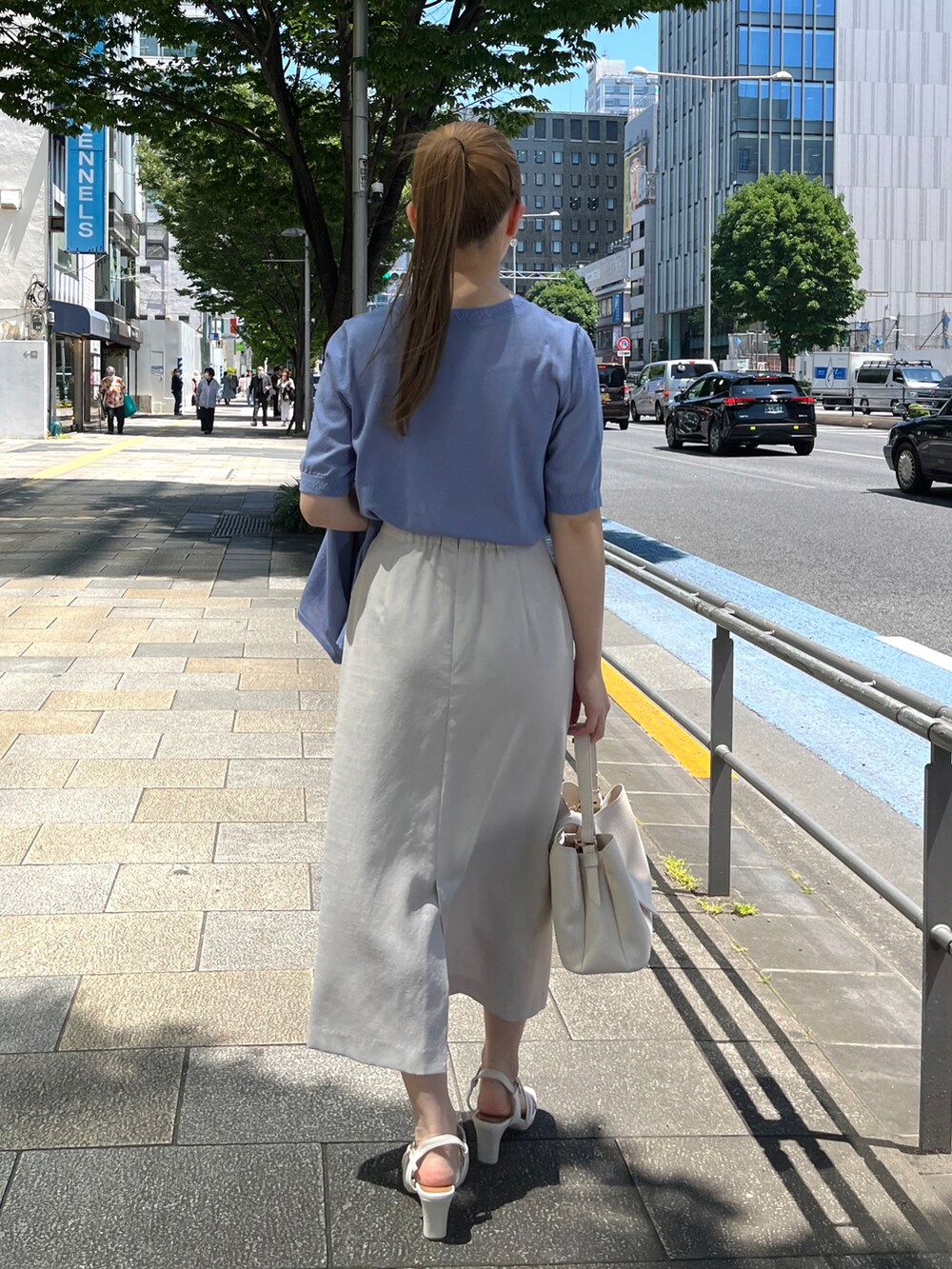 ブルー系のニット/セーター、ブルー系のカーディガン/ボレロ、ベージュ系のスカートを着用したレディースの春コーディネートの3枚目の写真