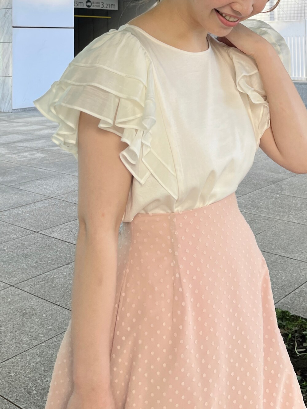 ホワイト系のTシャツ/カットソー、ピンク系のスカート、ベージュ系のハンドバッグを着用したレディースの春コーディネートの3枚目の写真