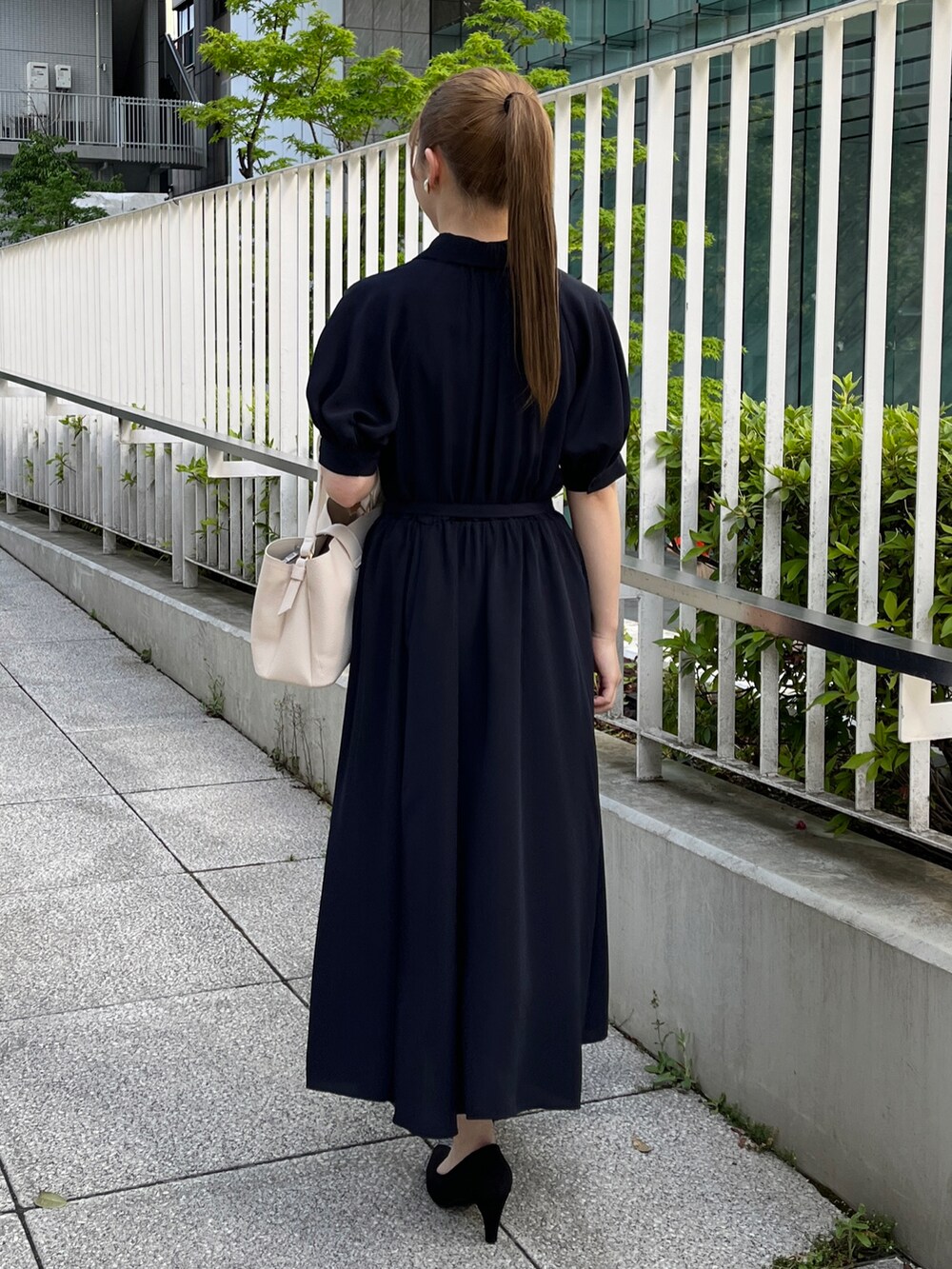 ホワイト系のカーディガン/ボレロ、ブルー系のワンピース、ブラック系のパンプスを着用したレディースの春コーディネートの3枚目の写真