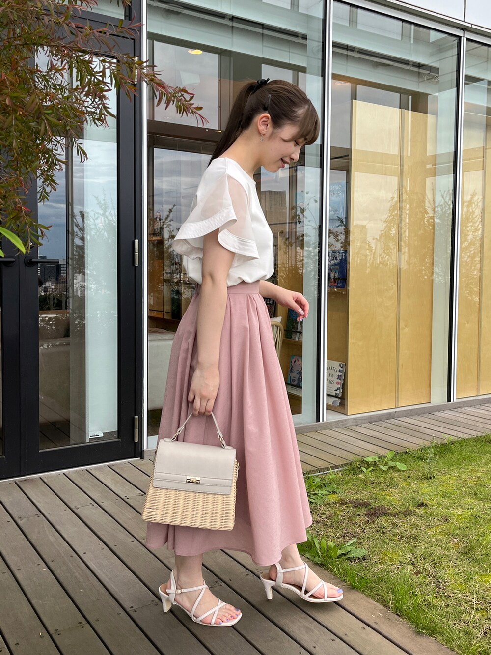 ホワイト系のTシャツ/カットソー、ピンク系のスカート、グレー系のショルダーバッグを着用したレディースの夏コーディネートの2枚目の写真