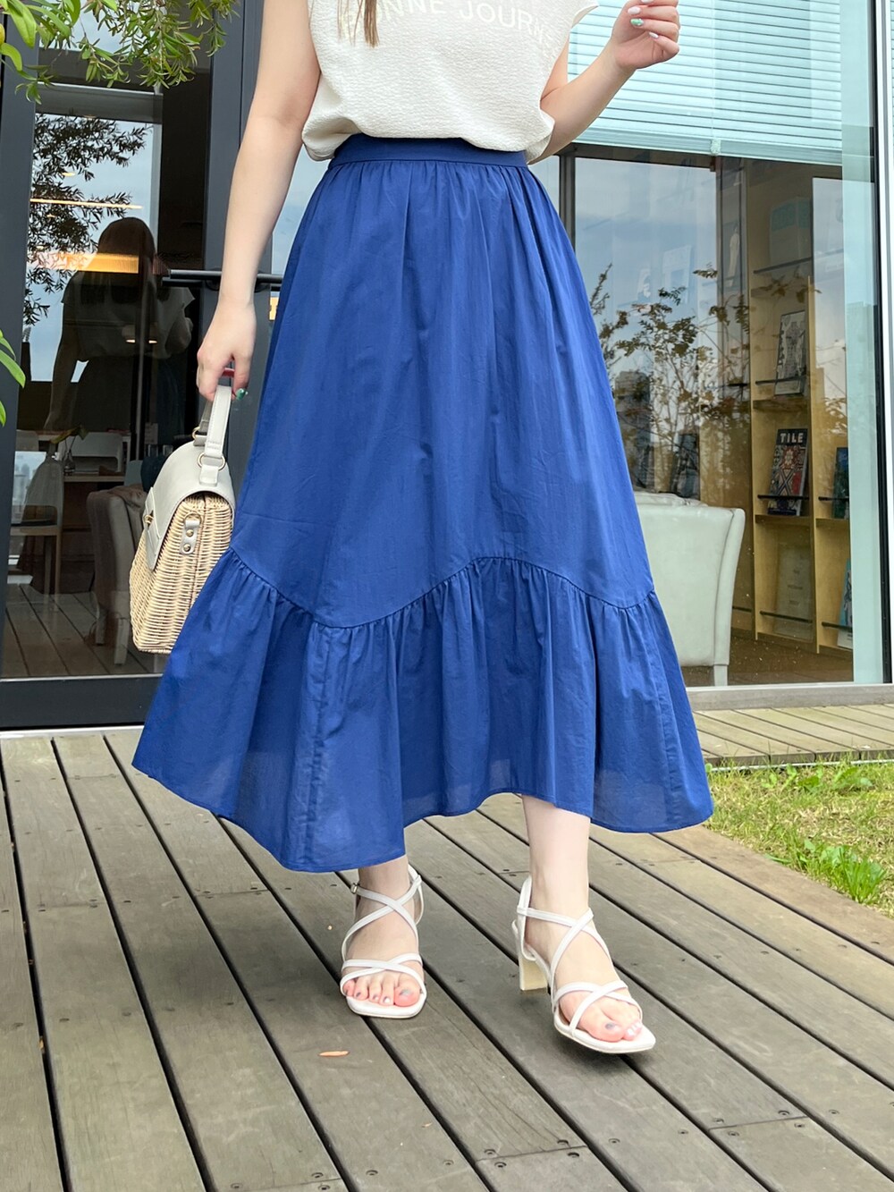 ホワイト系のTシャツ/カットソー、ブルー系のスカート、グレー系のショルダーバッグを着用したレディースの夏コーディネートの5枚目の写真