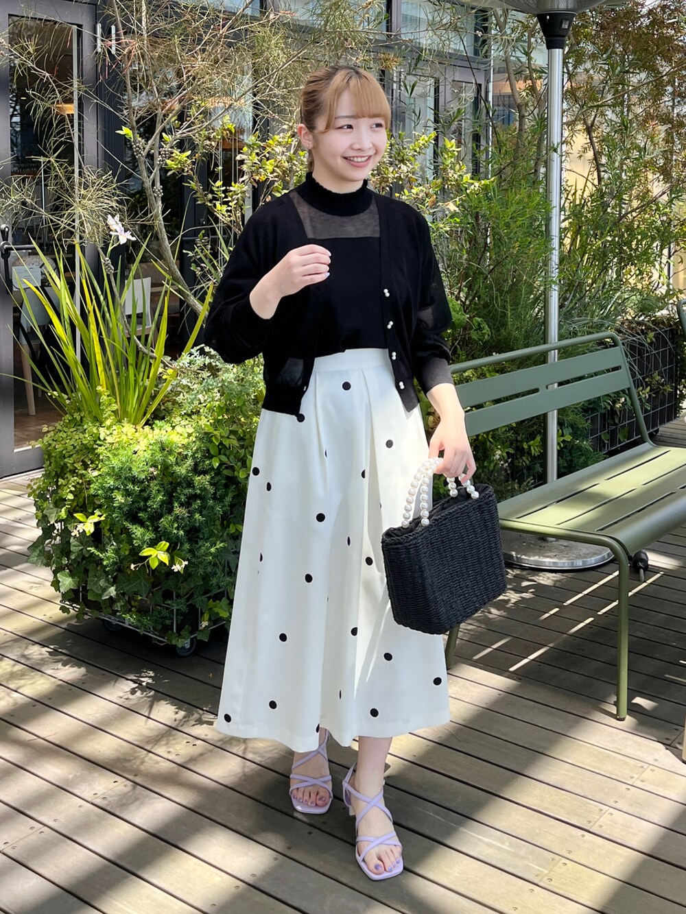 ブラック系のニット/セーター、ブラック系のカーディガン/ボレロ、ベージュ系のスカートを着用したレディースの夏コーディネートの5枚目の写真