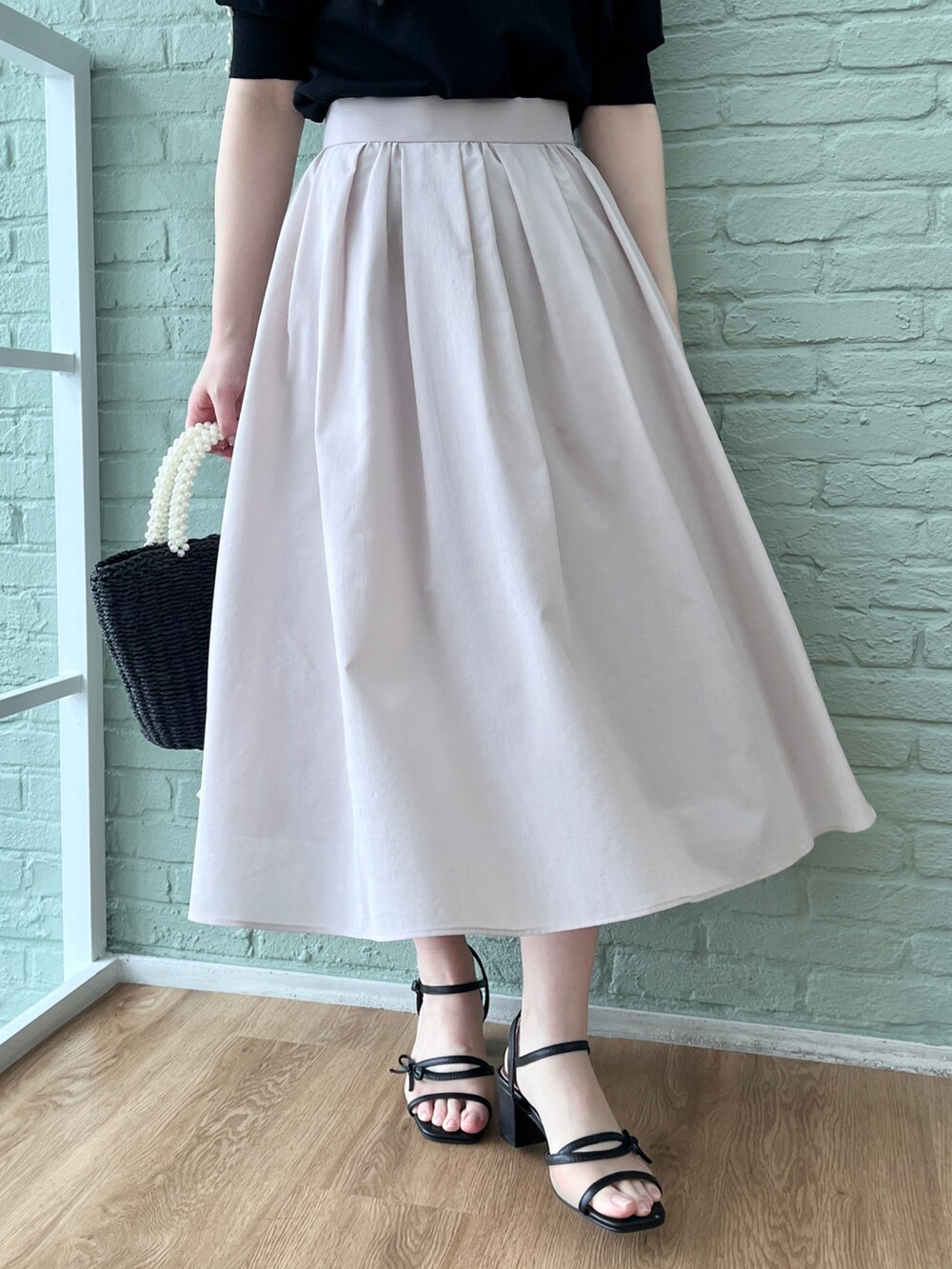 ブラック系のニット/セーター、グレー系のスカートを着用したレディースの春コーディネートの5枚目の写真