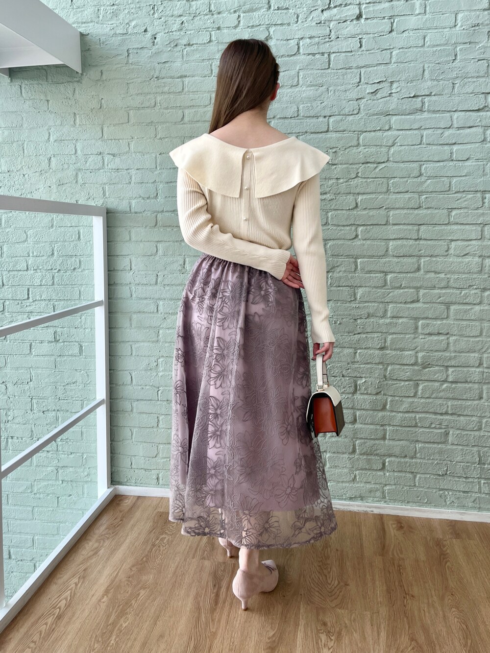 ホワイト系のニット/セーター、パープル系のスカートを着用したレディースの冬コーディネートの3枚目の写真