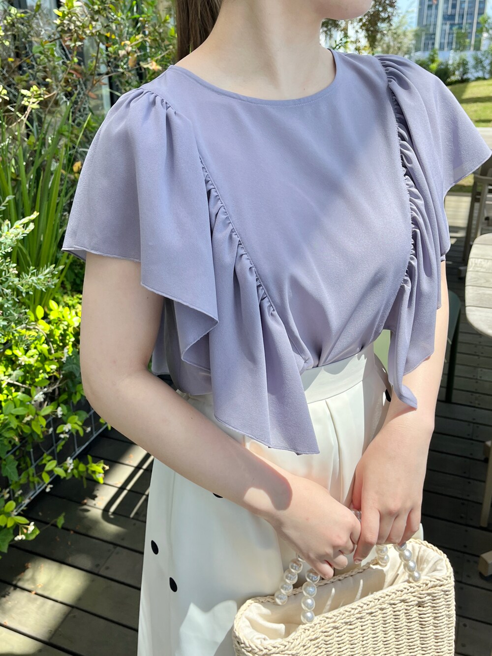 パープル系のシャツ/ブラウス、ベージュ系のスカート、ベージュ系のハンドバッグを着用したレディースの夏コーディネートの4枚目の写真