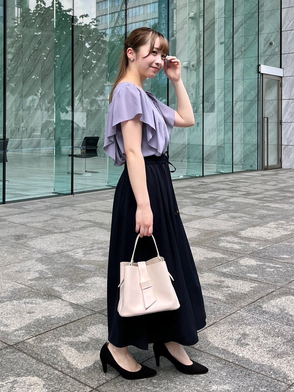 パープル系のシャツ/ブラウス、ホワイト系のショルダーバッグ、ブラック系のパンプスを着用したレディースの夏コーディネートの2枚目の写真