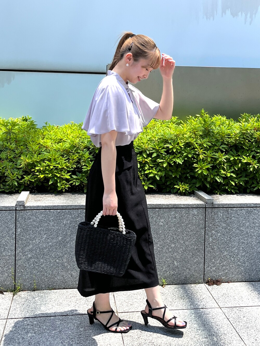 グレー系のシャツ/ブラウス、ブラック系のスカート、ブラック系のハンドバッグを着用したレディースの夏コーディネートの2枚目の写真
