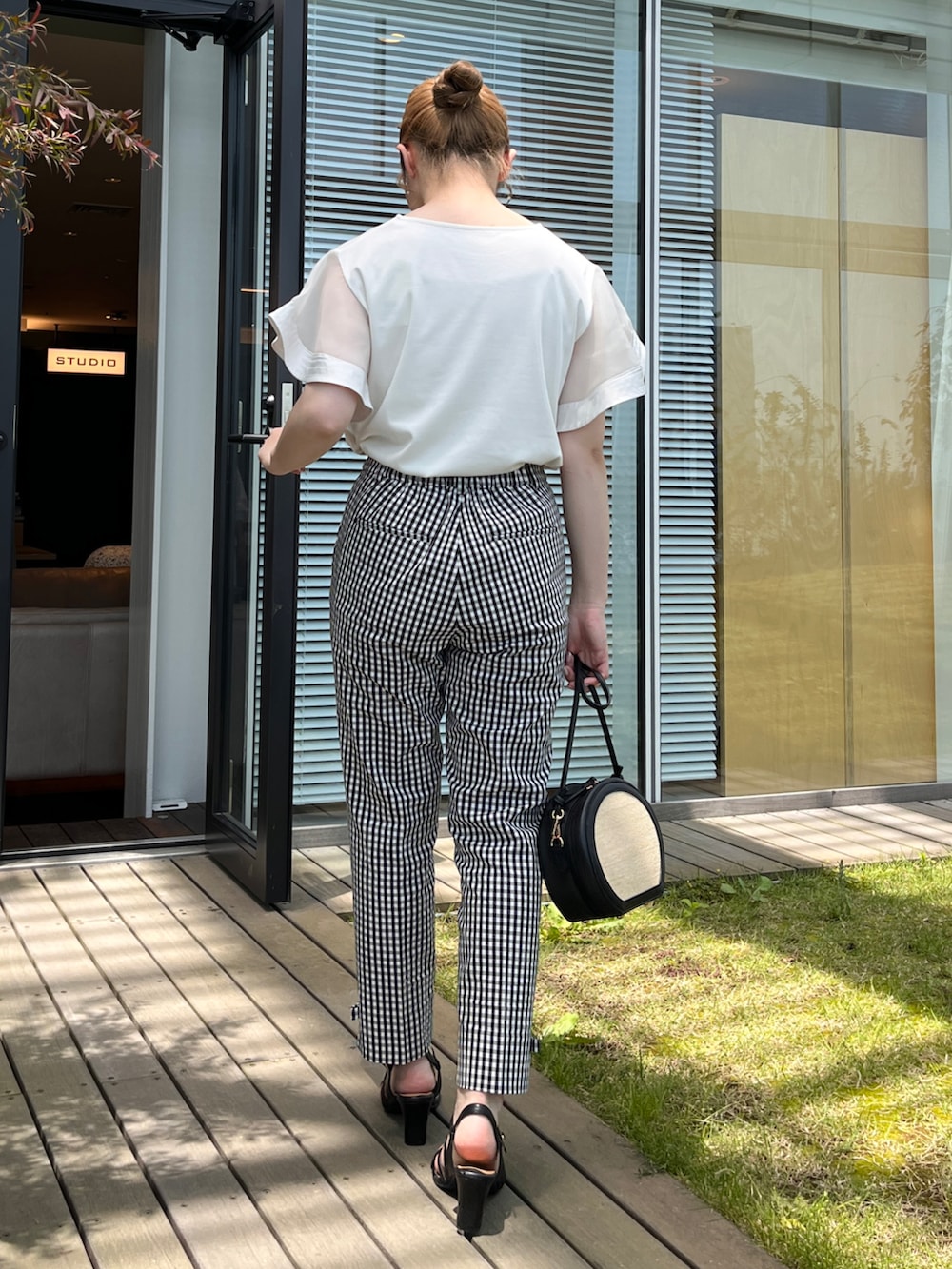 ホワイト系のTシャツ/カットソー、ブラック系のその他パンツ、ブラック系のショルダーバッグを着用したレディースの夏コーディネートの3枚目の写真