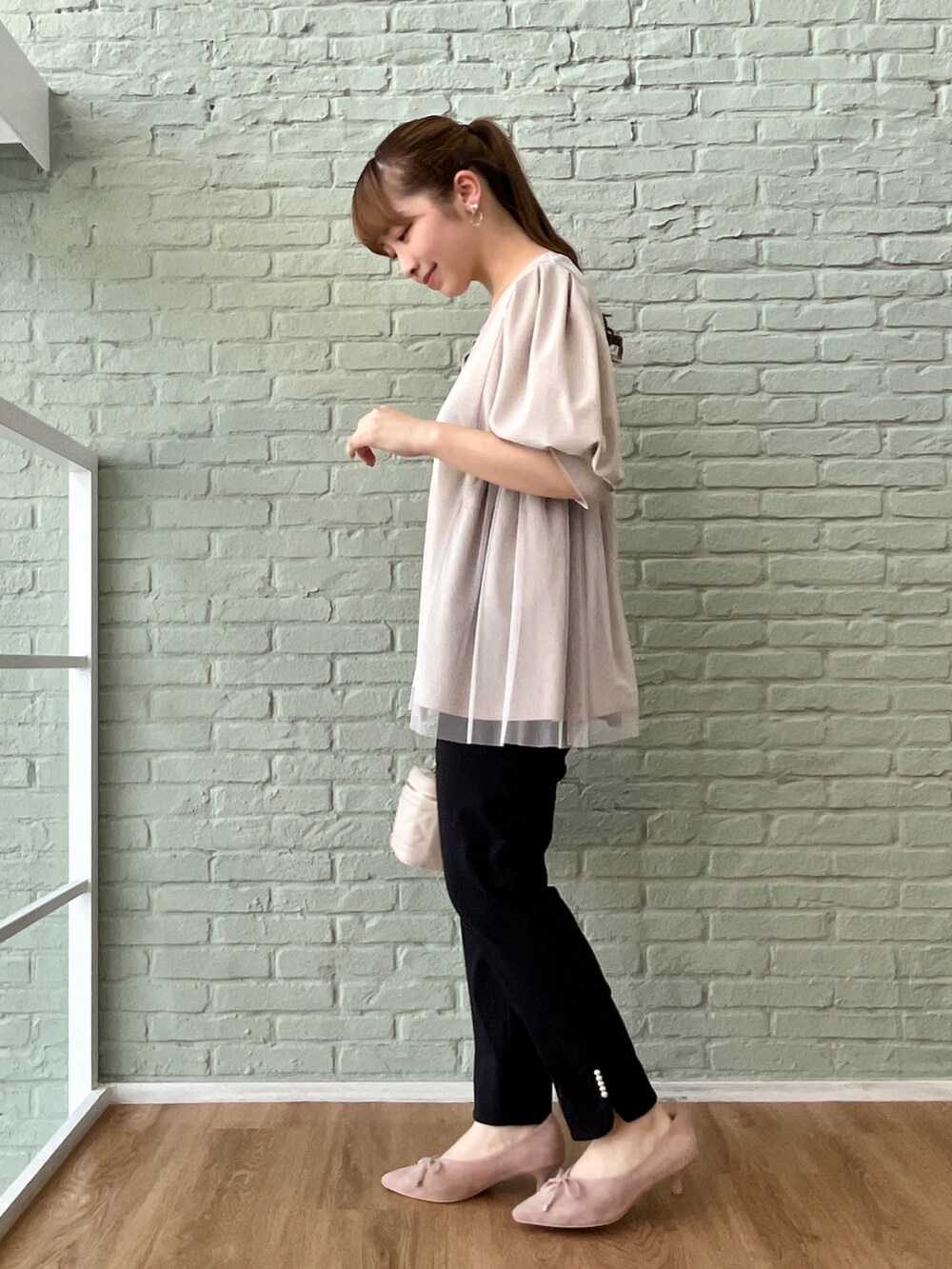 グレー系のチュニック、ブルー系のその他パンツ、ホワイト系のショルダーバッグを着用したレディースの夏コーディネートの2枚目の写真