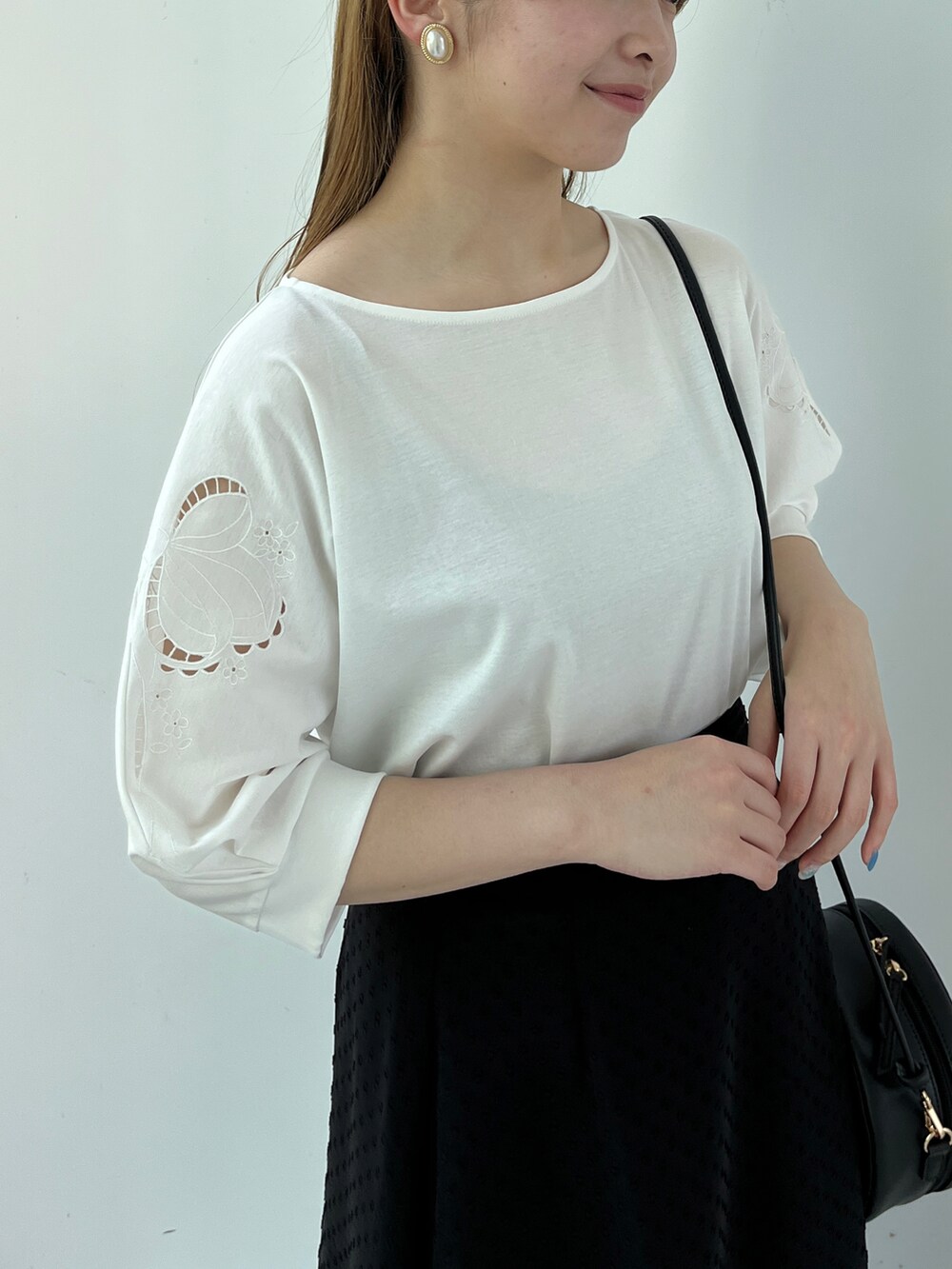 ホワイト系のTシャツ/カットソー、ブラック系のスカート、ホワイト系のサンダルを着用したレディースの春コーディネートの3枚目の写真