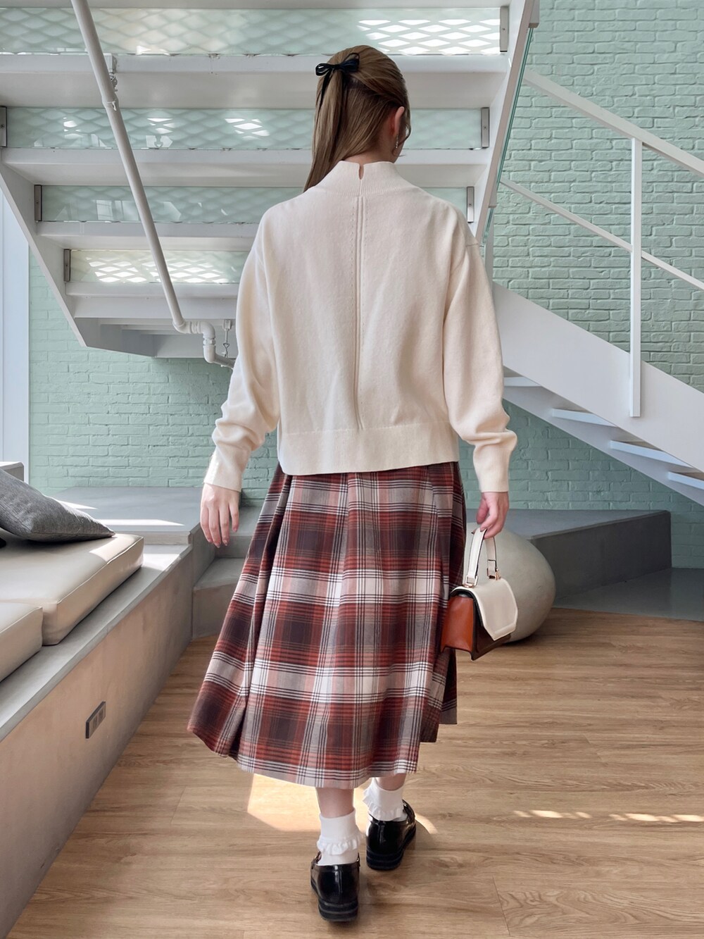 ホワイト系のニット/セーター、ブラウン系のスカート、ブラック系のその他シューズを着用したレディースの秋コーディネートの2枚目の写真