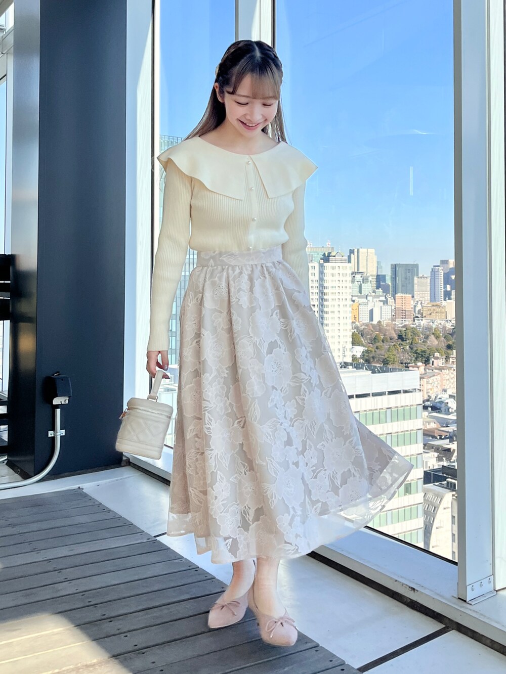 ベージュ系のブルゾン、ホワイト系のニット/セーター、ベージュ系のスカートを着用したレディースの冬コーディネートの4枚目の写真