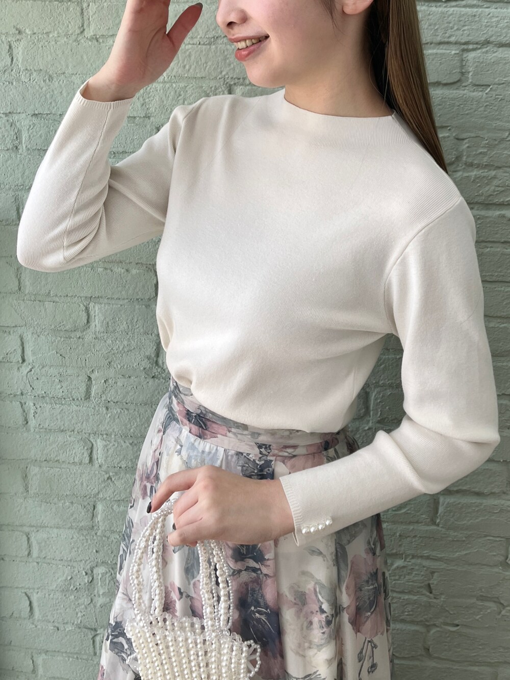 ホワイト系のニット/セーター、ベージュ系のスカートを着用したレディースの冬コーディネートの4枚目の写真