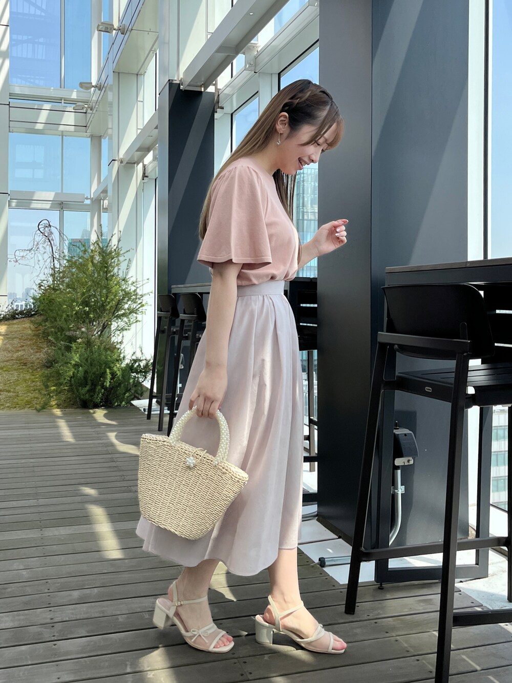 ピンク系のニット/セーター、グレー系のスカートを着用したレディースの春コーディネートの2枚目の写真