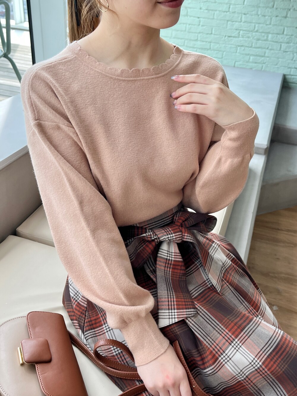 ピンク系のニット/セーター、ブラウン系のスカートを着用したレディースの秋コーディネートの3枚目の写真