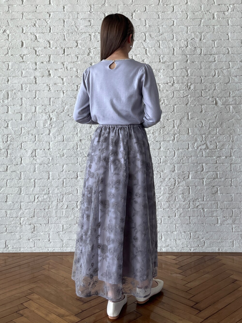 グレー系のスカート、パープル系のニット/セーターを着用したレディースの冬コーディネートの3枚目の写真