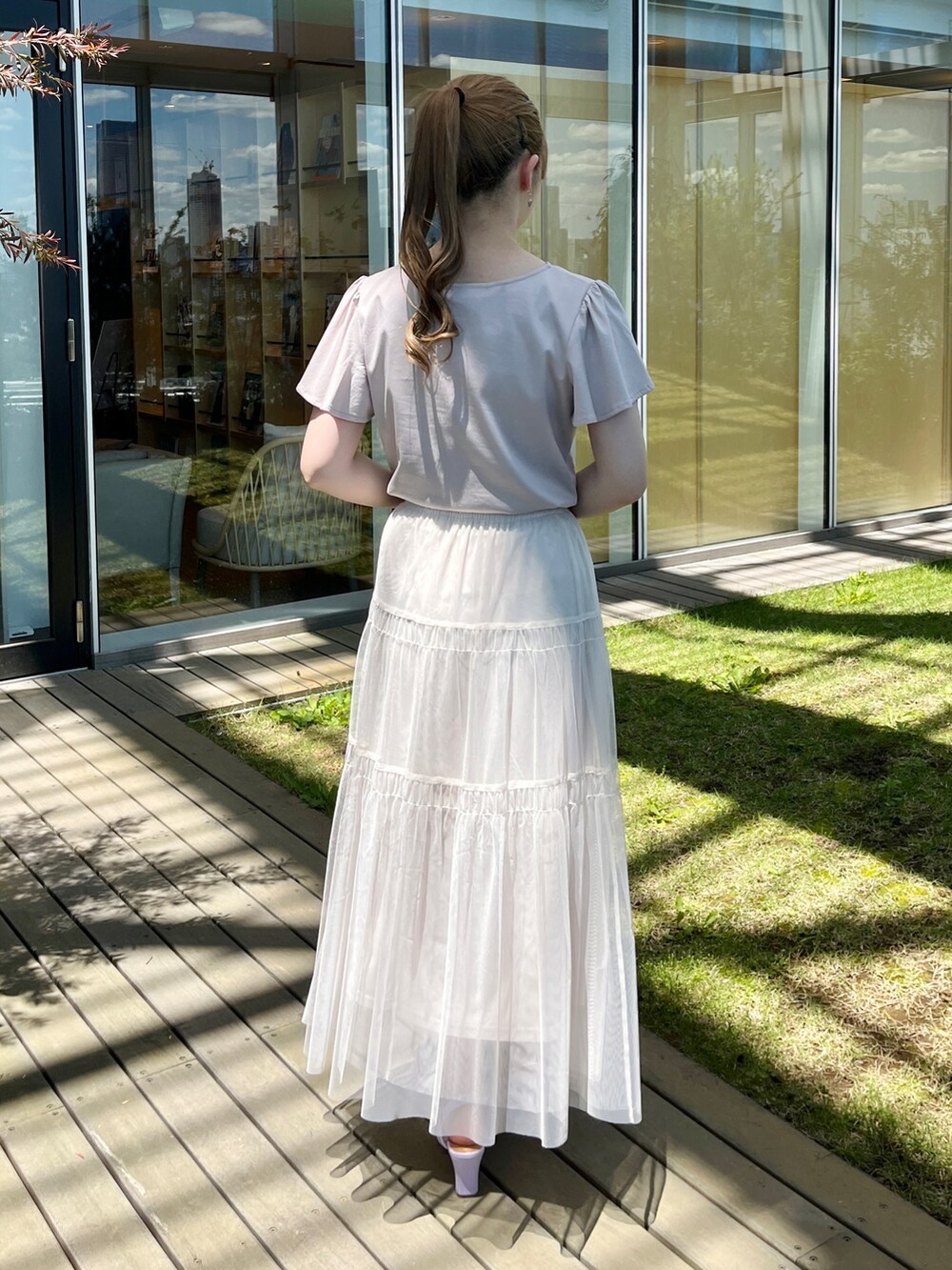 グレー系のTシャツ/カットソー、ホワイト系のスカート、グレー系のショルダーバッグを着用したレディースの夏コーディネートの3枚目の写真