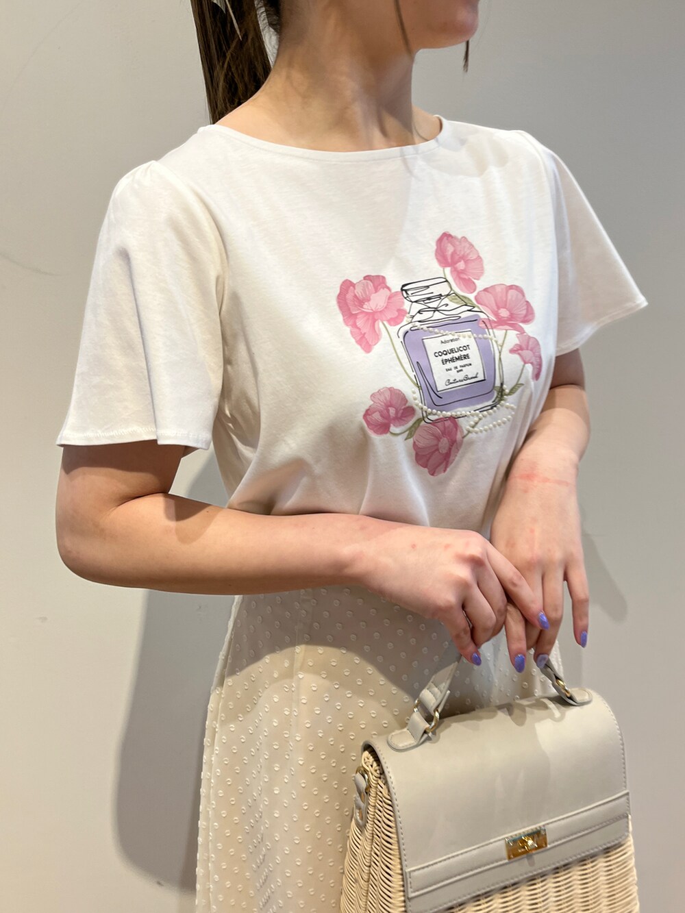 ホワイト系のTシャツ/カットソー、ホワイト系のスカート、グレー系のショルダーバッグを着用したレディースの春コーディネートの4枚目の写真