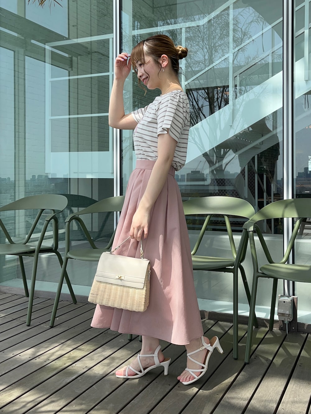 ベージュ系のTシャツ/カットソー、ピンク系のスカート、グレー系のショルダーバッグを着用したレディースの春コーディネートの2枚目の写真