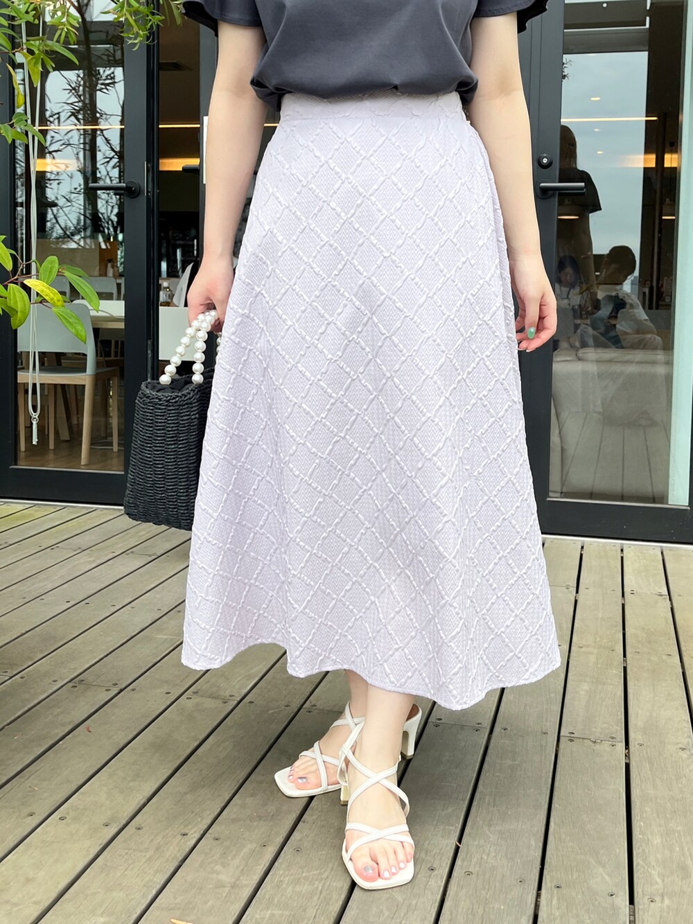 グレー系のTシャツ/カットソー、ブラック系のハンドバッグ、ホワイト系のサンダルを着用したレディースの夏コーディネートの5枚目の写真