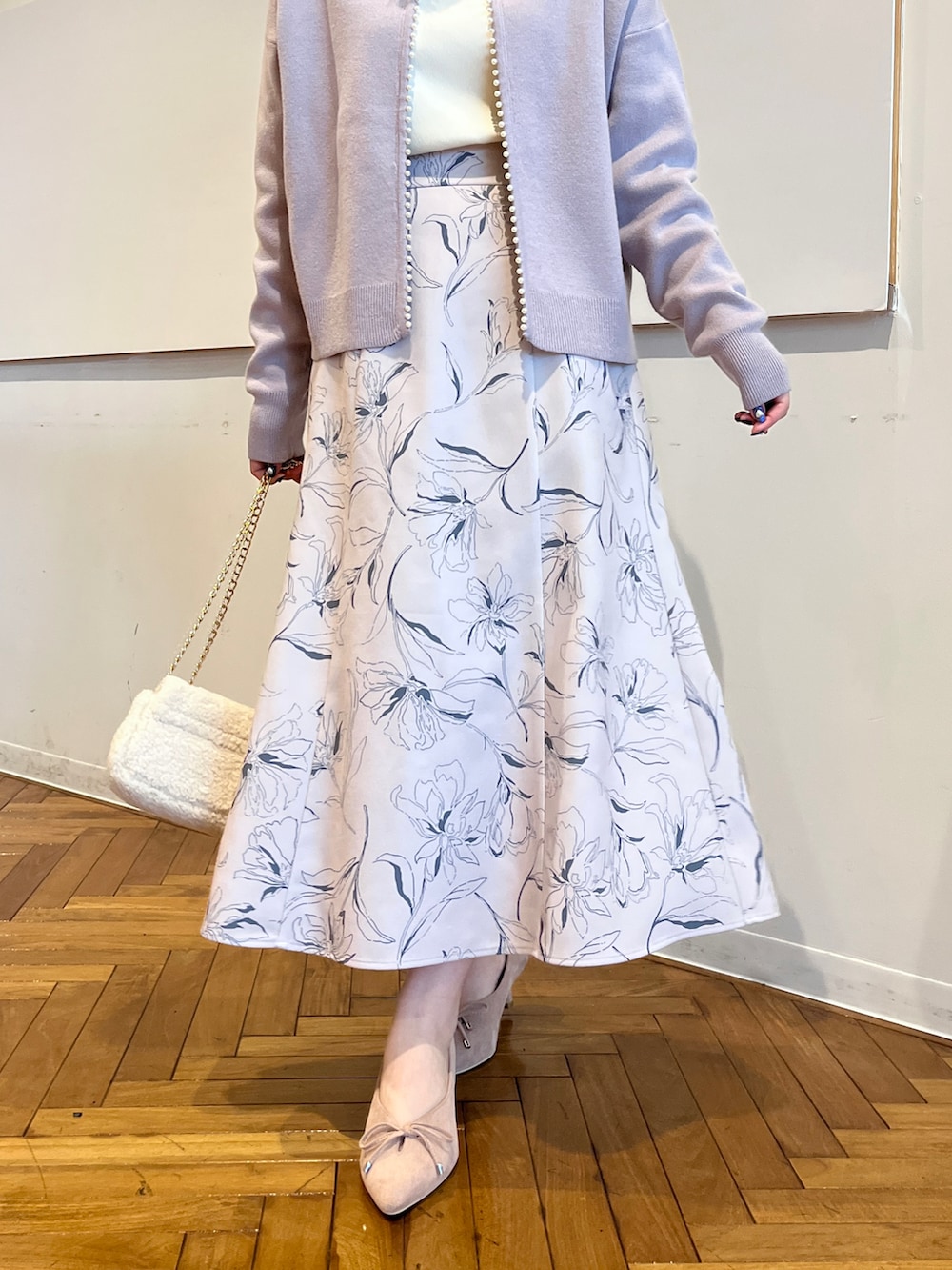 ブルー系のカーディガン/ボレロ、ベージュ系のスカート、ホワイト系のTシャツ/カットソーを着用したレディースの秋コーディネートの5枚目の写真