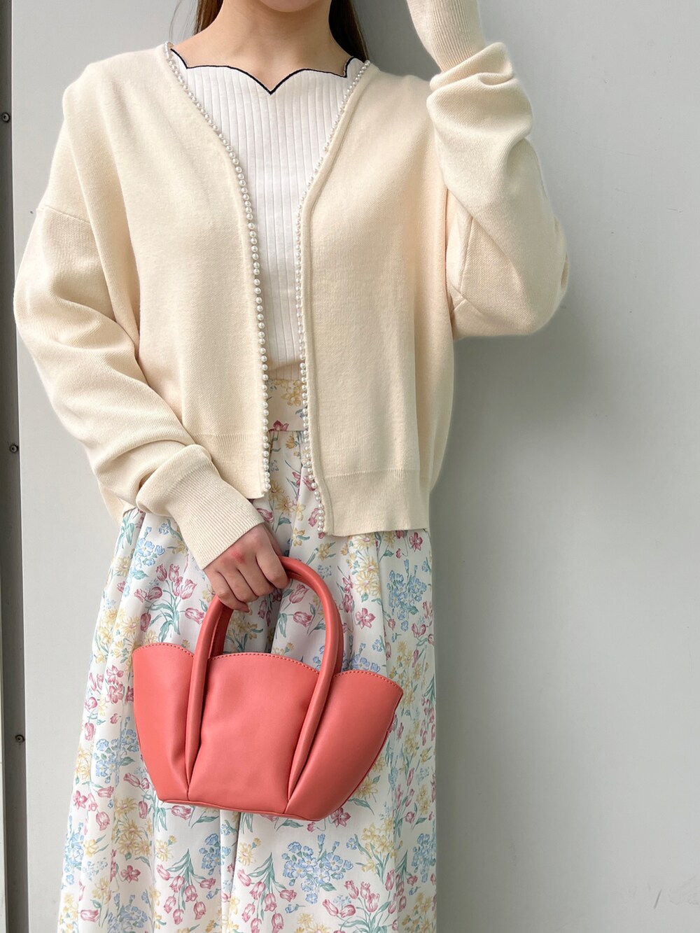 ホワイト系のTシャツ/カットソー、ホワイト系のカーディガン/ボレロ、ベージュ系のスカートを着用したレディースの冬コーディネートの4枚目の写真