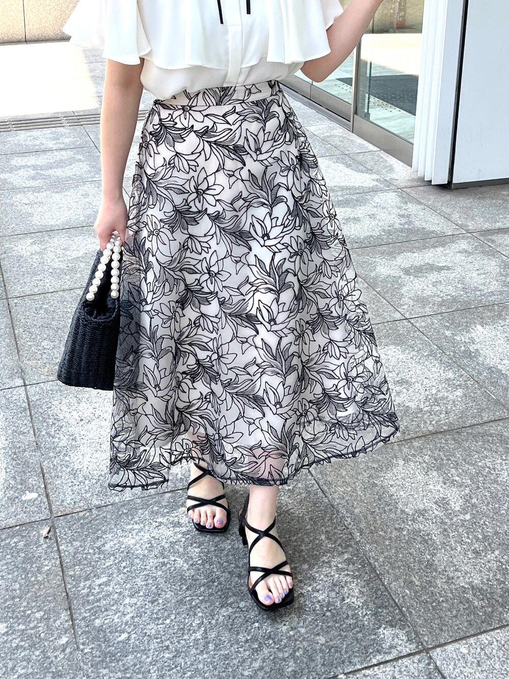 ホワイト系のシャツ/ブラウス、ブラック系のスカート、ブラック系のハンドバッグを着用したレディースの夏コーディネートの5枚目の写真