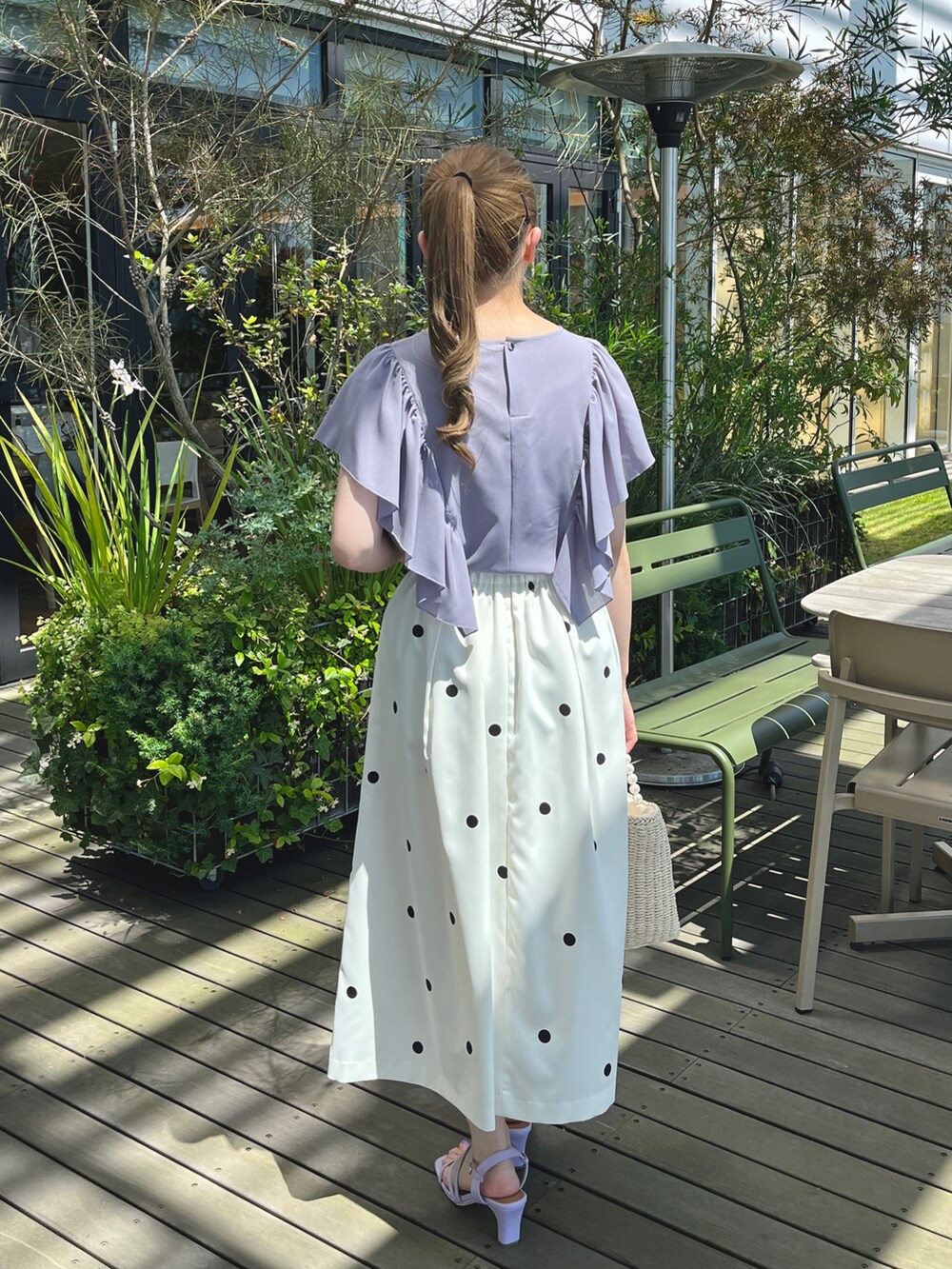 パープル系のシャツ/ブラウス、ベージュ系のスカート、ベージュ系のハンドバッグを着用したレディースの夏コーディネートの3枚目の写真