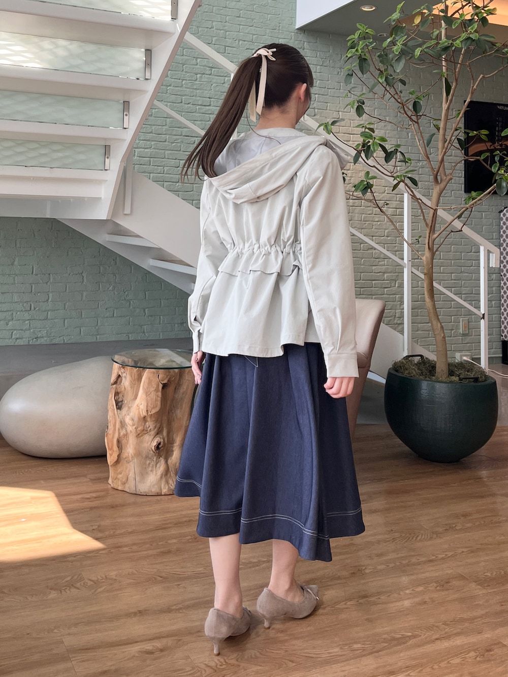 グリーン系のブルゾン、ブルー系のワンピースを着用したレディースの冬コーディネートの3枚目の写真