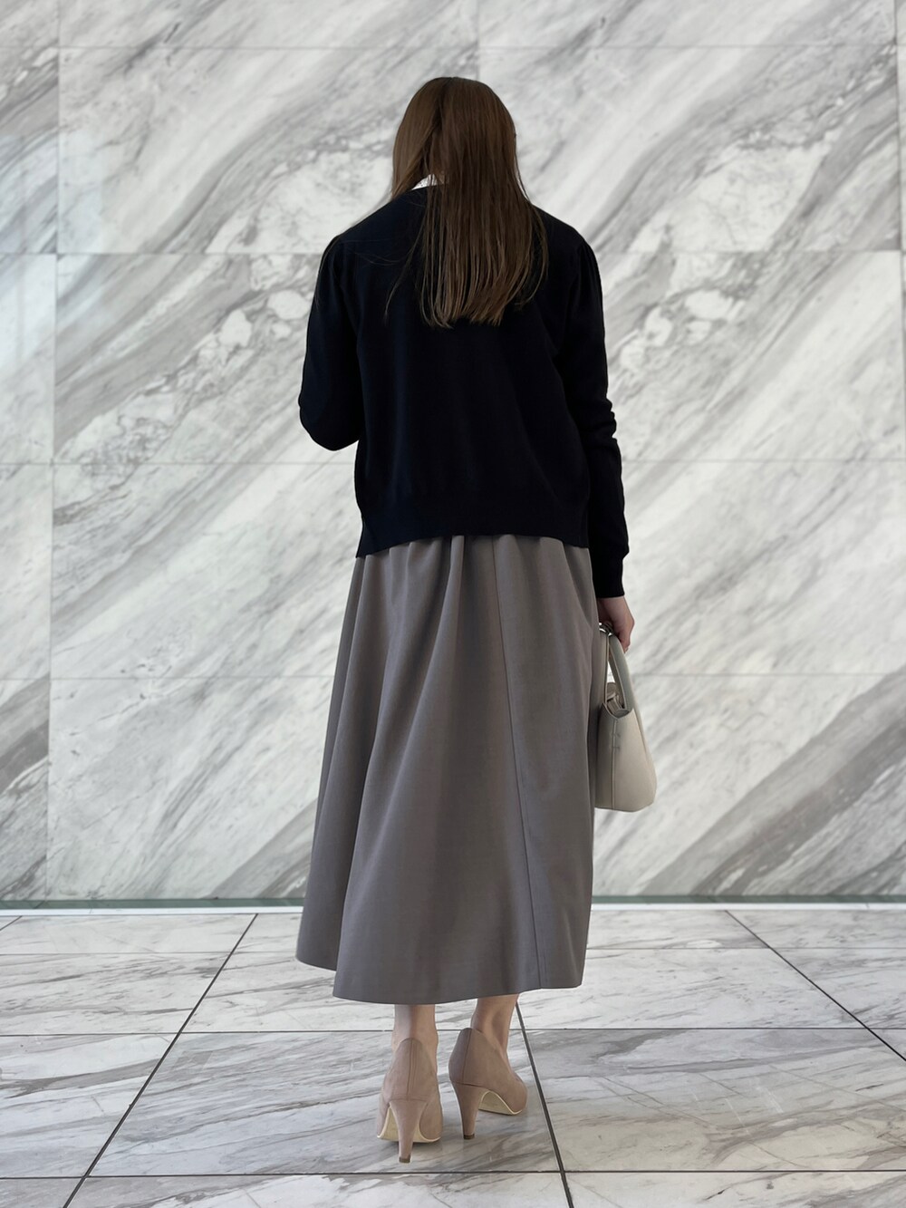 ホワイト系のシャツ/ブラウス、ブラック系のカーディガン/ボレロ、ブラウン系のスカートを着用したレディースの冬コーディネートの3枚目の写真